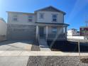 Two-story home features gray siding, a stone accent garage, front porch and concrete driveway at 21934 E 39Th Ave, Aurora, CO 80019