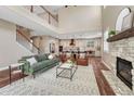 Open-concept living room with fireplace that flows into a gourmet kitchen; great natural lighting at 10761 Hillsboro Cir, Parker, CO 80134