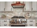 Close up on the stainless steel, gas range with a decorative hood at 10761 Hillsboro Cir, Parker, CO 80134