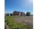 A Large outbuilding featuring multiple bays and a tractor to the side at 13291 N Harback Rd, Bennett, CO 80102
