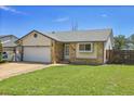 Inviting single-story home featuring an attached garage, well-kept lawn and traditional design at 7610 S Garland St, Littleton, CO 80128