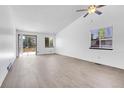 Bright living room featuring hardwood floors, fresh paint, ample windows, and sliding glass door at 7610 S Garland St, Littleton, CO 80128