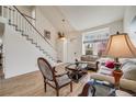 Open-concept living room with a staircase, hardwood floors, and ample natural light at 9032 W Arizona Dr, Lakewood, CO 80232