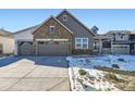 Inviting exterior of a home featuring a stone and siding facade and a three-car garage at 3856 Treadway Pt, Castle Rock, CO 80108