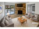 Virtually staged living room with stone fireplace and patio access at 4450 S Pitkin St # 128, Aurora, CO 80015