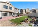 Spacious backyard with artificial lawn, patio, seating, and decorative landscaping at 18284 E 52Nd Pl, Denver, CO 80249