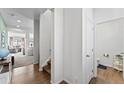 Bright hallway with wood floors, staircase, and a half-bath. The living room is visible in the background at 18284 E 52Nd Pl, Denver, CO 80249