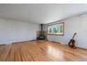 Inviting living area featuring hardwood floors, wood-burning stove, and a large bay window with natural light at 29827 Gigi Rd, Evergreen, CO 80439
