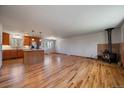 Spacious open-concept living area with hardwood floors, island, and a cozy wood-burning stove at 29827 Gigi Rd, Evergreen, CO 80439