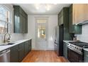 Modern kitchen with dark green cabinetry, stainless steel appliances, and white tile backsplash at 2929 N Josephine St, Denver, CO 80205