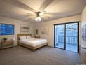 Bright bedroom with a ceiling fan, ensuite bath, and sliding glass doors to a private outdoor balcony at 10293 E Peakview Ave # F104, Englewood, CO 80111