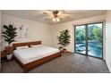 Bright bedroom with large windows offering serene views of lush landscaping and a wooden bed frame at 10293 E Peakview Ave # F104, Englewood, CO 80111