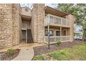 Multi-level condo exterior with stone accents, private balconies, and well-maintained landscaping and open stairwell at 10293 E Peakview Ave # F104, Englewood, CO 80111