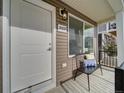 Inviting front porch with bench, modern door, and house number at 10306 Uvalda Ct, Commerce City, CO 80022
