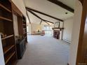 Spacious living room boasts exposed beams, a cozy fireplace, built-in shelving, and large windows for natural light at 2100 Robb St, Lakewood, CO 80215