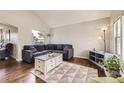 Comfortable living room with high ceilings, hardwood floors, and a large sectional sofa at 1663 E 96Th Pl, Thornton, CO 80229