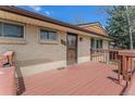 Inviting front porch area featuring brick exterior and wooden deck at 4395 E Arapahoe Pl, Centennial, CO 80122