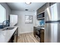 Bright kitchen with stainless steel appliances, stunning blue tile backsplash, and in-unit laundry at 361 N Raleigh St, Denver, CO 80219