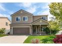 Beautiful two-story home featuring neutral siding, a covered entry, an attached garage, and a neatly kept front lawn at 5400 Perth St, Denver, CO 80249