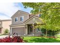 Inviting two-story home with a covered front porch, attached garage, and well-manicured lawn, perfect for Gathering living at 5400 Perth St, Denver, CO 80249