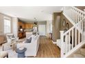 Bright living room with hardwood floors, open to the kitchen and adjacent to staircase at 3415 Florence Way, Denver, CO 80238