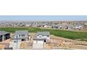 Wide aerial shot showcasing a community with manicured lawns, walking path, and mountain views at 11033 Olathe St, Commerce City, CO 80022