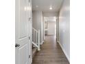 Inviting hallway with neutral paint, white trim, and wood-look flooring leads to other rooms, and an upper level at 1866 Sawtooth Mountain Dr, Berthoud, CO 80513