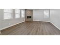 Bright living room showcases wood floors, a stylish fireplace, and multiple windows for natural light at 1866 Sawtooth Mountain Dr, Berthoud, CO 80513