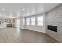 Spacious living room featuring wood floors, a modern fireplace, large windows, and an open concept layout at 1866 Sawtooth Mountain Dr, Berthoud, CO 80513