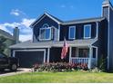 Charming two-story home with a blue exterior, well-manicured lawn, and a cozy front porch at 8653 Red Clover Ct, Parker, CO 80134