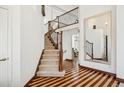 Welcoming home foyer featuring elegant staircase, striking wood floors, and a large mirror enhancing the bright, open space at 9714 Chanteclair Cir, Highlands Ranch, CO 80126