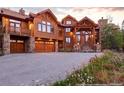 Beautiful log home featuring stone accents, an attached garage, and a well-maintained driveway at 378 Juniata Cir, Breckenridge, CO 80424