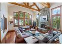 Cozy living room with a stone fireplace, wood beams, and large windows offering scenic views at 378 Juniata Cir, Breckenridge, CO 80424