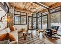 Inviting living room features a fireplace, comfortable seating, and scenic views of the snow-covered landscape at 2383 Tiger Rd, Breckenridge, CO 80424