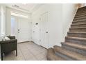 Bright entryway with tile flooring, a coat closet and access to the carpeted stairs to the second floor at 20017 E 48Th Pl, Denver, CO 80249