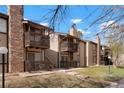 Exterior shot of the condo building, showing balconies, stone chimney, and well-manicured landscaping at 1842 S Pitkin Cir # A, Aurora, CO 80017