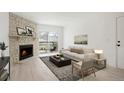 Staged living room featuring a stone fireplace, balcony access, and stylish decor at 1842 S Pitkin Cir # A, Aurora, CO 80017