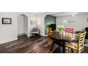 Bright dining area featuring hardwood floors, colorful chairs, and stylish decor accents with decorative green wall at 1293 S Perry St, Denver, CO 80219