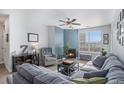 Cozy living room with a fireplace, ceiling fan, and large window for natural light at 17297 Wilde Ave # 205, Parker, CO 80134