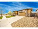 Well-kept home showcasing stone details, neat landscaping, and a lengthy driveway at 15484 E 115Th Ave, Commerce City, CO 80022
