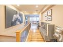 Upstairs hallway with wooden floors, neutral walls, and access to living spaces at 15484 E 115Th Ave, Commerce City, CO 80022