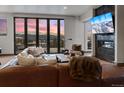 Inviting living room with fireplace, large windows boasting mountain views, and leather sectional at 310 N Fuller Placer Rd, Breckenridge, CO 80424