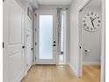 Bright entryway with wood floors, white door, side window, coat closet, and view to the powder room at 4232 Jason St # 7, Denver, CO 80211