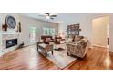 Bright living room with hardwood floors, fireplace, ceiling fan, and stylish furnishings at 21107 Hawthorne Ln, Parker, CO 80138