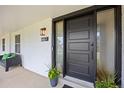 Stylish modern front door with sleek black frame, decorative plants, and a cozy bench on the welcoming porch at 5853 S Havana Ct, Englewood, CO 80111