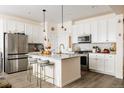 Stylish kitchen with stainless steel appliances, granite countertops, an island with seating, and modern light fixtures at 10845 Bear Cub Dr, Broomfield, CO 80021