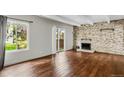 Bright living room boasting hardwood floors, stone fireplace, and sliding glass doors to a deck at 9995 E Harvard Ave # 290, Denver, CO 80231