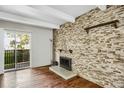 Cozy living room featuring a stone fireplace and a sliding door leading to a private balcony at 9995 E Harvard Ave # 290, Denver, CO 80231