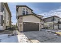 Charming two-story home features a gray two-car garage with stone accents and landscaped front at 1660 Candleflower Dr, Castle Pines, CO 80108