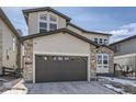 Two-story home showcasing a two-car garage, stone accents, and a well-maintained front yard at 1660 Candleflower Dr, Castle Pines, CO 80108
